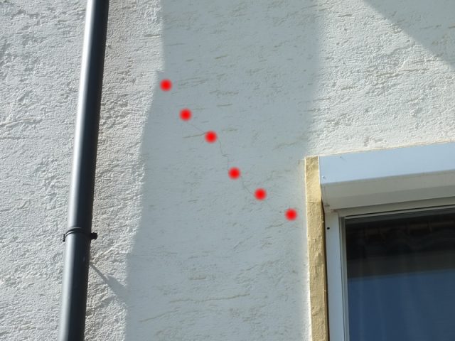 schräge im Risse im Putz zeigen Setzrisse an, Zugspannung = Setzung ist senkrecht zum Riss, also in Richtung Fundament links